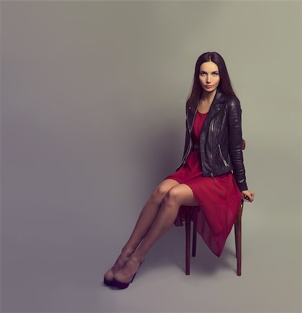 Sexy Brunette Woman in Red Fashion Dress and Leather Jacket Sitting on a Chair. Copy Space. Toned Photo. Stock Photo - Budget Royalty-Free & Subscription, Code: 400-07461951