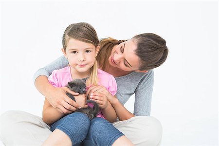 Happy daughter and mother sitting with pet kitten together on white background Stock Photo - Budget Royalty-Free & Subscription, Code: 400-07474331