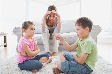 Fed up mother listening to her young children argue at home in the living room Stock Photo - Budget Royalty-Free & Subscription, Code: 400-07474342