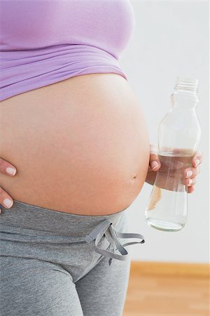 simsearch:400-06690931,k - Pregnant woman holding bottle of water in a fitness studio Fotografie stock - Microstock e Abbonamento, Codice: 400-07474418