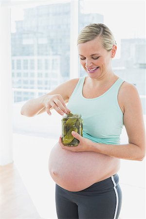 simsearch:400-06690931,k - Blonde pregnant woman eating from jar of pickles in a fitness studio Fotografie stock - Microstock e Abbonamento, Codice: 400-07474438