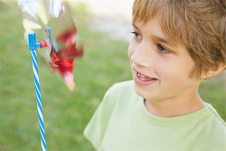 Smiling young boy looking at pinwheel in the park Stock Photo - Budget Royalty-Free & Subscription, Code: 400-07474888