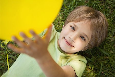 High angle view of a young boy with yellow balloon at the park Stock Photo - Budget Royalty-Free & Subscription, Code: 400-07474906