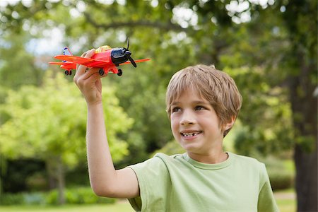 simsearch:400-07474903,k - Excited young boy playing with a toy plane at the park Foto de stock - Super Valor sin royalties y Suscripción, Código: 400-07474903