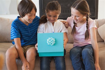 simsearch:6109-07601570,k - Happy young kids with gift box in the living room at home Stockbilder - Microstock & Abonnement, Bildnummer: 400-07474958