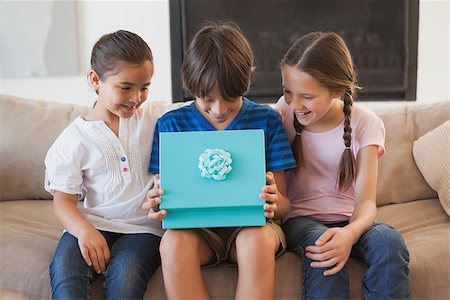 simsearch:6109-07601570,k - Happy young kids with gift box in the living room at home Stockbilder - Microstock & Abonnement, Bildnummer: 400-07474959