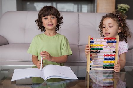 simsearch:6109-07601494,k - Portrait of siblings with book and abacus in the living room at home Stock Photo - Budget Royalty-Free & Subscription, Code: 400-07475216