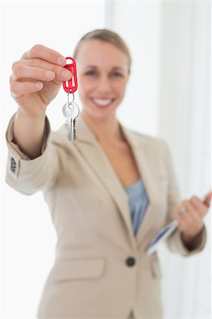 simsearch:400-07475963,k - Smiling estate agent showing keys to camera in empty house Stock Photo - Budget Royalty-Free & Subscription, Code: 400-07475961