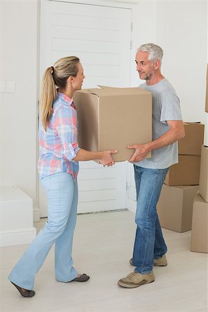 simsearch:400-07928013,k - Happy couple carrying cardboard moving boxes in new home Fotografie stock - Microstock e Abbonamento, Codice: 400-07475976