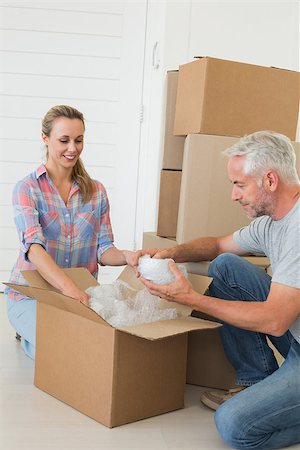 simsearch:400-07928013,k - Happy couple unpacking cardboard moving boxes in their new home Fotografie stock - Microstock e Abbonamento, Codice: 400-07475985