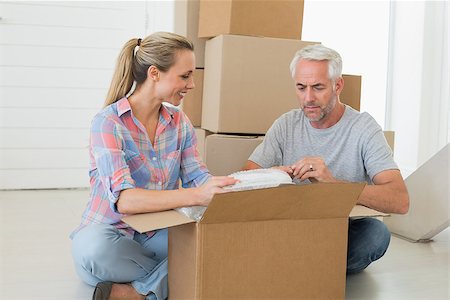 simsearch:400-07928013,k - Happy couple unpacking cardboard moving boxes in their new home Fotografie stock - Microstock e Abbonamento, Codice: 400-07475989