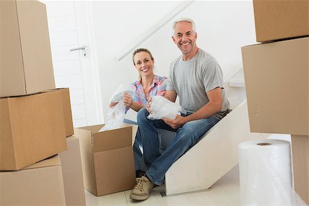 simsearch:400-07928013,k - Happy couple unpacking cardboard moving boxes in their new home Fotografie stock - Microstock e Abbonamento, Codice: 400-07475994