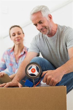 simsearch:400-07928013,k - Happy couple sealing cardboard moving boxes in their old home Fotografie stock - Microstock e Abbonamento, Codice: 400-07475999