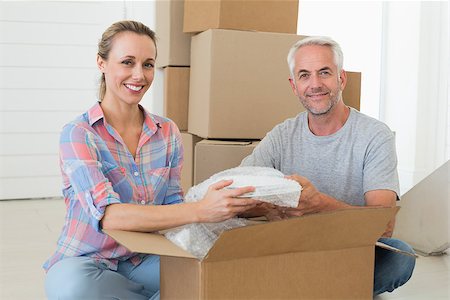 simsearch:400-07928013,k - Happy couple unpacking cardboard moving boxes in their new home Fotografie stock - Microstock e Abbonamento, Codice: 400-07475991