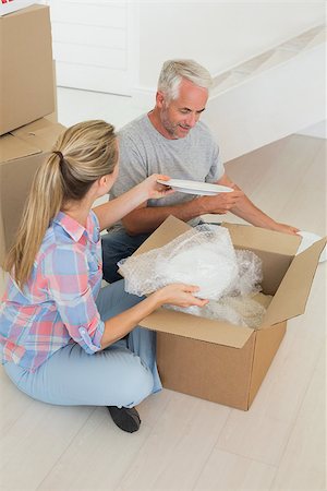 simsearch:400-07928013,k - Happy couple unpacking cardboard moving boxes in their new home Fotografie stock - Microstock e Abbonamento, Codice: 400-07475992