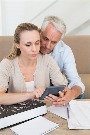 simsearch:400-07333928,k - Serious couple calculating their bills at the couch at home in the living room Stock Photo - Budget Royalty-Free & Subscription, Code: 400-07476035