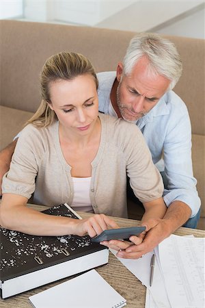 simsearch:400-07333928,k - Serious couple calculating their bills at the couch at home in the living room Stock Photo - Budget Royalty-Free & Subscription, Code: 400-07476037