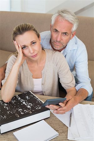 simsearch:400-07333928,k - Serious couple calculating their bills at the couch at home in the living room Stock Photo - Budget Royalty-Free & Subscription, Code: 400-07476039