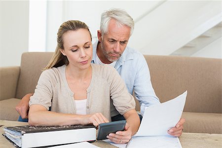 simsearch:400-07333928,k - Serious couple calculating their bills at the couch at home in the living room Stock Photo - Budget Royalty-Free & Subscription, Code: 400-07476032