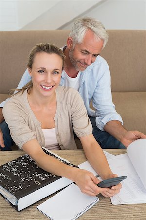 simsearch:400-07333928,k - Smiling couple calculating their bills at the couch at home in the living room Stock Photo - Budget Royalty-Free & Subscription, Code: 400-07476040