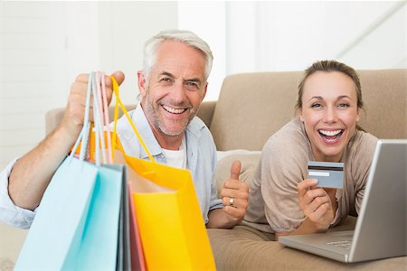 simsearch:400-07474252,k - Happy couple shopping online on the couch at home in the living room Stock Photo - Budget Royalty-Free & Subscription, Code: 400-07476064