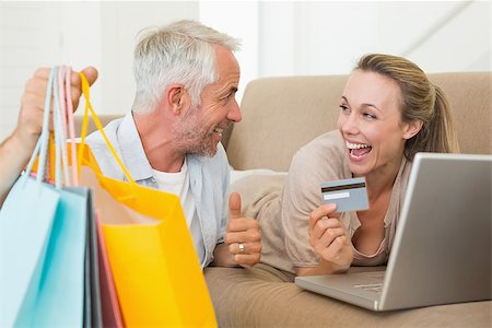 simsearch:400-07474252,k - Happy couple shopping online on the couch at home in the living room Stock Photo - Budget Royalty-Free & Subscription, Code: 400-07476065