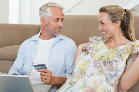simsearch:400-07474252,k - Happy couple shopping online on the couch at home in the living room Stock Photo - Budget Royalty-Free & Subscription, Code: 400-07476069