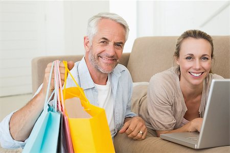 simsearch:400-07474252,k - Happy couple shopping online on the couch at home in the living room Stock Photo - Budget Royalty-Free & Subscription, Code: 400-07476063