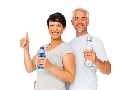 exercise for women over 50 years old - Portrait of a happy fit couple with water bottles gesturing thumbs up over white background Stock Photo - Budget Royalty-Free & Subscription, Code: 400-07476246