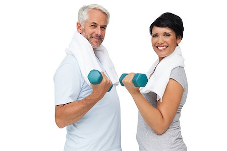 exercise for women over 50 years old - Portrait of a fit mature couple exercising with dumbbells over white background Stock Photo - Budget Royalty-Free & Subscription, Code: 400-07476255