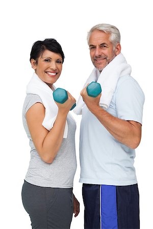 fitness   mature woman - Portrait of a fit mature couple exercising with dumbbells over white background Stock Photo - Budget Royalty-Free & Subscription, Code: 400-07476256