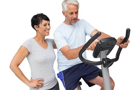 exercise for women over 50 years old - Happy woman looking at mature man on stationary bike over white background Stock Photo - Budget Royalty-Free & Subscription, Code: 400-07476260