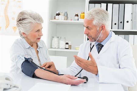 Doctor taking the blood pressure of his retired patient in the medical office Stock Photo - Budget Royalty-Free & Subscription, Code: 400-07476387