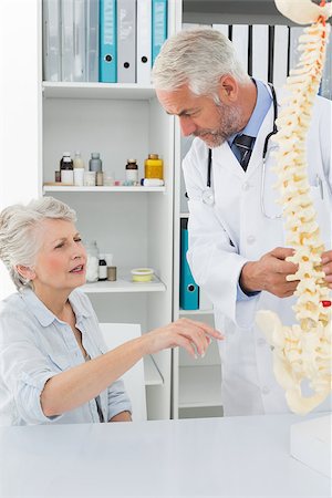 Male doctor explaining the spine to senior patient at desk in medical office Stock Photo - Budget Royalty-Free & Subscription, Code: 400-07476392