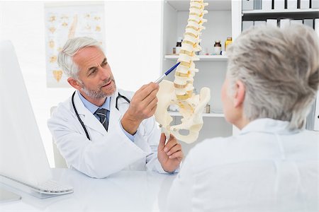 Male doctor explaining the spine to senior patient at desk in medical office Stock Photo - Budget Royalty-Free & Subscription, Code: 400-07476424