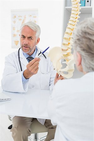 Male doctor explaining the spine to senior patient at desk in medical office Stock Photo - Budget Royalty-Free & Subscription, Code: 400-07476425