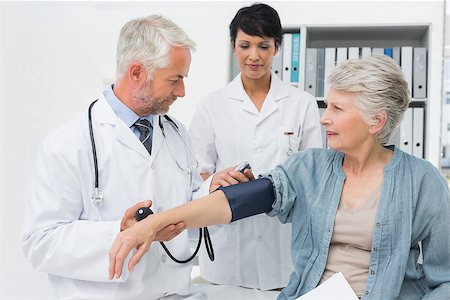 Male doctor measuring blood pressure of a senior patient in the medical office Stock Photo - Budget Royalty-Free & Subscription, Code: 400-07476459