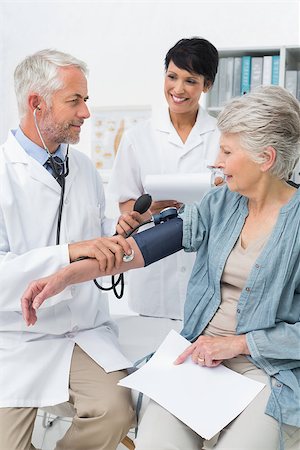 Male doctor measuring blood pressure of a senior patient in the medical office Stock Photo - Budget Royalty-Free & Subscription, Code: 400-07476460