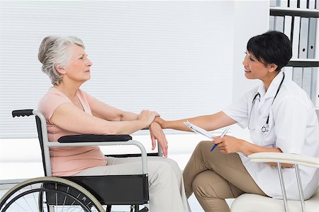 Side view of a doctor talking to a senior patient in wheelchair at the hospital Fotografie stock - Microstock e Abbonamento, Codice: 400-07476514