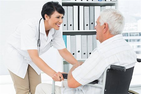 Side view of a female doctor talking to senior patient in wheelchair at the hospital Fotografie stock - Microstock e Abbonamento, Codice: 400-07476527