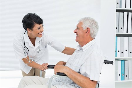 Side view of a female doctor talking to senior patient in wheelchair at the hospital Fotografie stock - Microstock e Abbonamento, Codice: 400-07476532