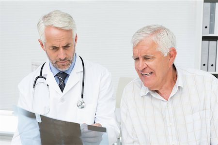 simsearch:400-07269250,k - Male doctor explaining x-ray report to senior patient in the medical office Stock Photo - Budget Royalty-Free & Subscription, Code: 400-07476574