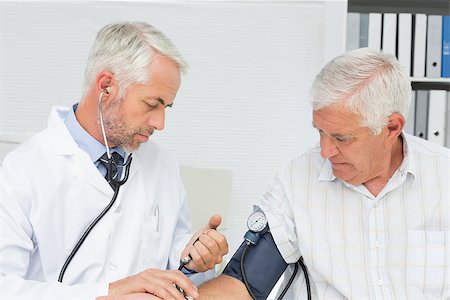 Doctor taking the blood pressure of his retired patient in the medical office Stock Photo - Budget Royalty-Free & Subscription, Code: 400-07476591