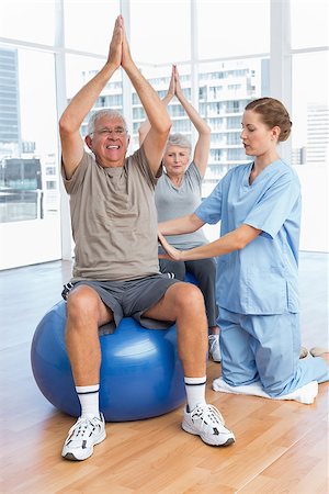 simsearch:400-07335332,k - Female therapist assisting senior couple with exercises in the medical office Fotografie stock - Microstock e Abbonamento, Codice: 400-07476646