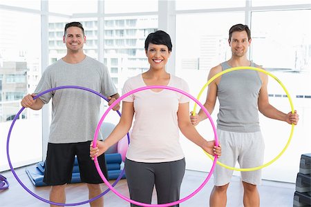 Portrait of fitness class holding hula hoops in bright gym Stock Photo - Budget Royalty-Free & Subscription, Code: 400-07476749