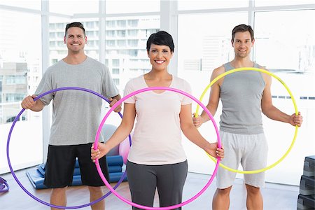 Portrait of fitness class holding hula hoops in bright gym Foto de stock - Super Valor sin royalties y Suscripción, Código: 400-07476749