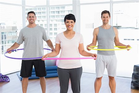 Portrait of fitness class holding hula hoops around waist in bright gym Stock Photo - Budget Royalty-Free & Subscription, Code: 400-07476750