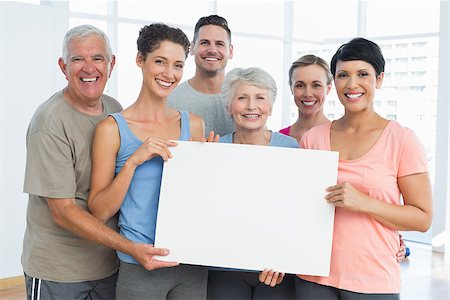 simsearch:400-06418716,k - Portrait of happy fit people holding blank board in the yoga class Foto de stock - Royalty-Free Super Valor e Assinatura, Número: 400-07476851