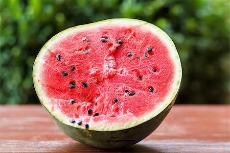 red water melon - Fresh juicy watermelon against natural green background in spring park Photographie de stock - Aubaine LD & Abonnement, Code: 400-07477474