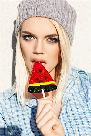 simsearch:400-07509968,k - Beautiful sexy blond girl with smokey eye makeup licks watermelon lollipop with her plump passionate lips Stock Photo - Budget Royalty-Free & Subscription, Code: 400-07477508